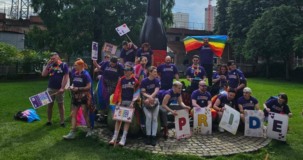 The UoM Manchester Pride parade team group photo by the iconic Vimto statue, summer 2023.